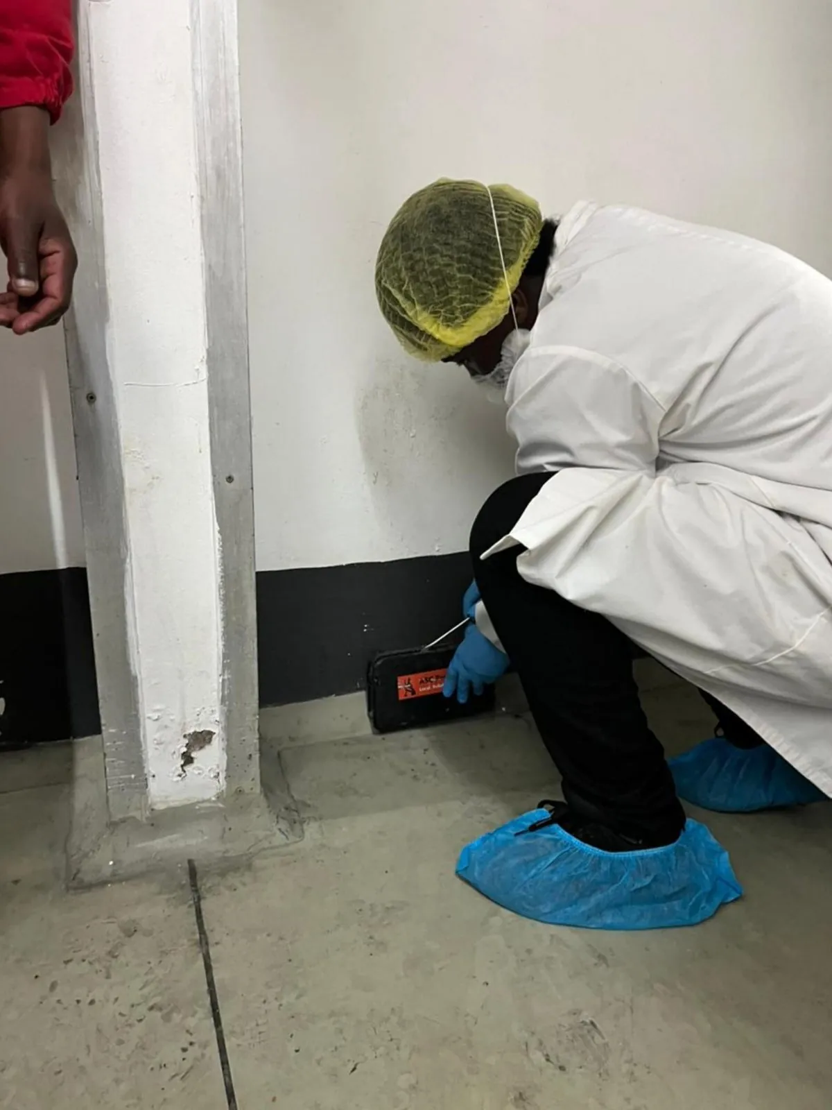ASC Pest Control technician taking a verification swab near a monitoring point
